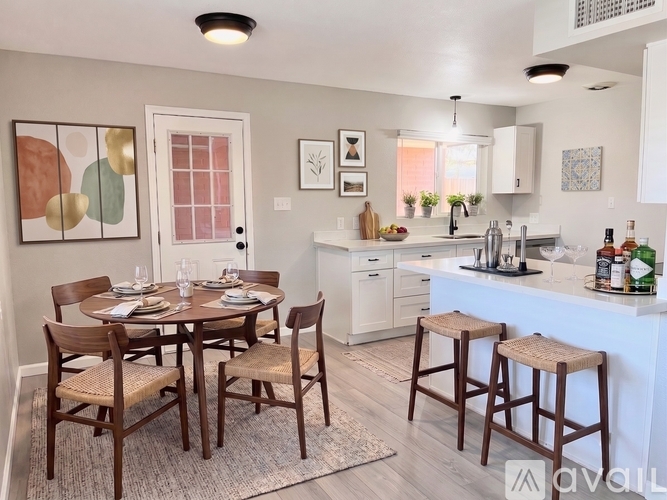 A kitchen with white cabinets and a black fridge.
