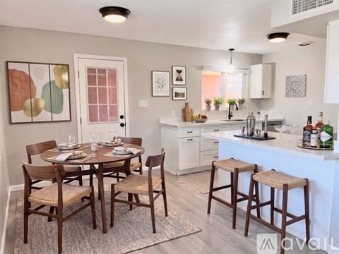 A kitchen with white cabinets and a black fridge.