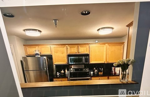 A kitchen with wooden cabinets and a black countertop.