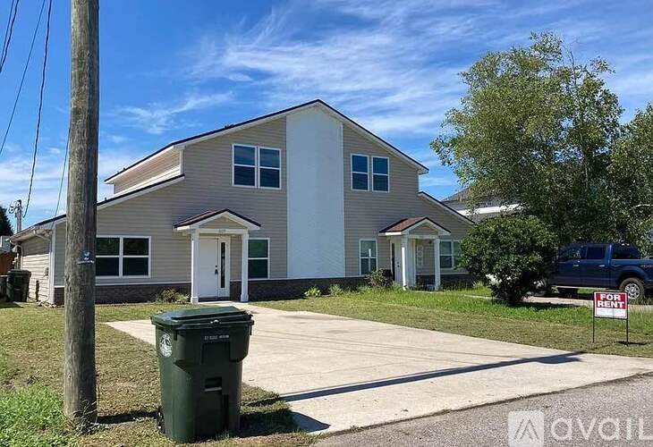 A house with a for sale sign in front of it.