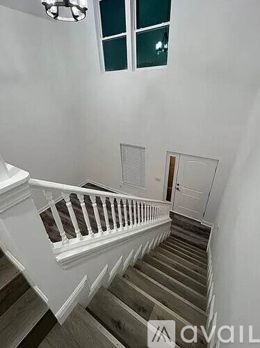 A staircase with a white railing and wooden steps.