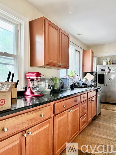 A kitchen with wooden cabinets and a black countertop.