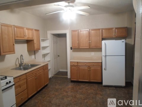 A kitchen with wooden cabinets and a white refrigerator.