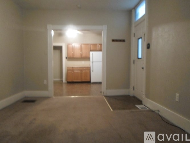 A room with a carpeted floor and a door leading to another room.