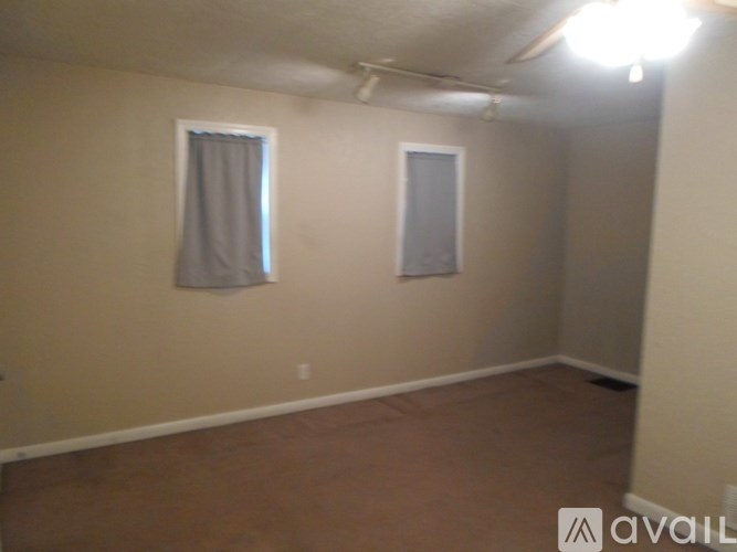 A room with a window and a door is available for rent.