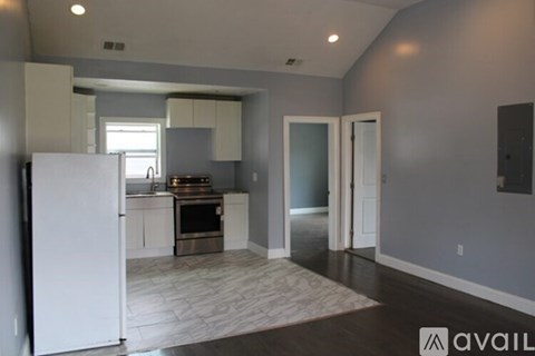 A kitchen with a white refrigerator and a white door is shown.