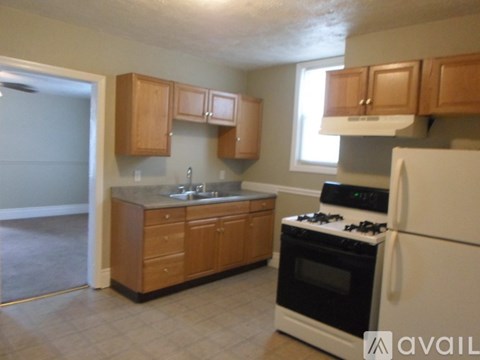 A kitchen with wooden cabinets and a white refrigerator.