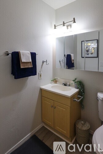 A bathroom with a wooden cabinet and a white sink.