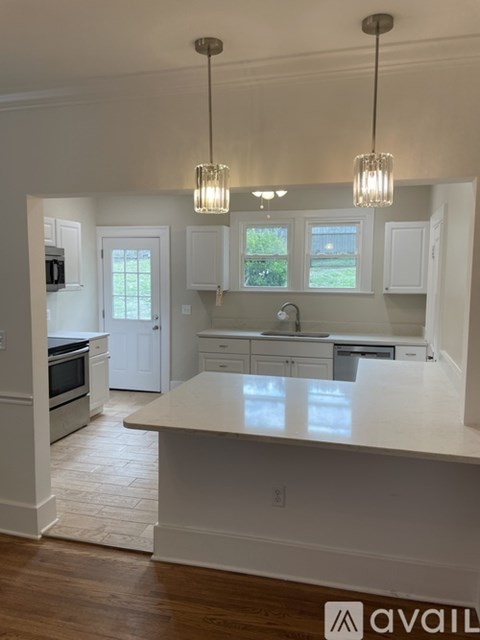A kitchen with white cabinets and a large island.