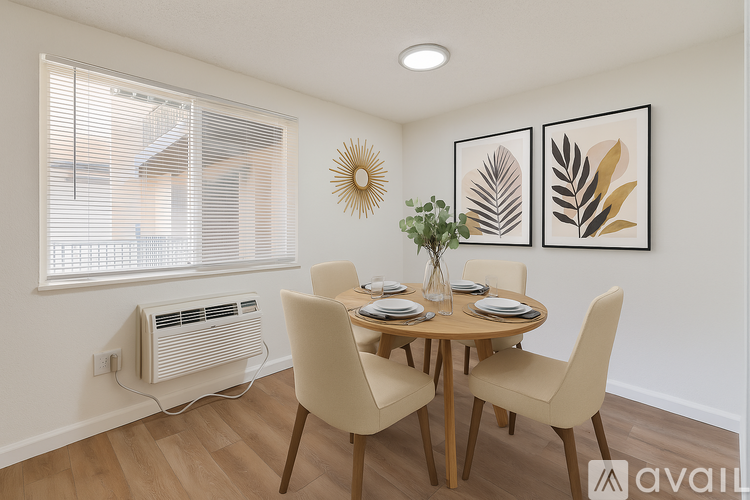 A dining room with a table set for two and a wall art of a leaf.