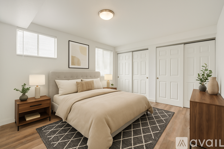 A well-lit bedroom with a large bed and a wooden nightstand.