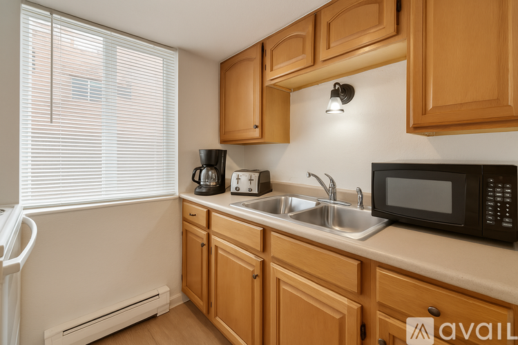 A kitchen with wooden cabinets and a black microwave.