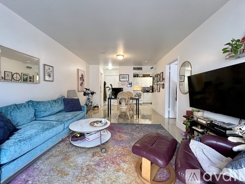 A living room with a blue couch and a white coffee table.