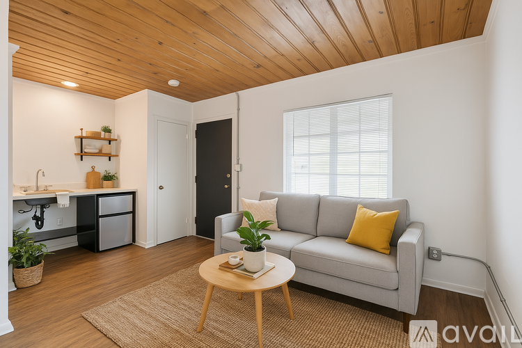 A living room with a grey couch and a wooden ceiling.