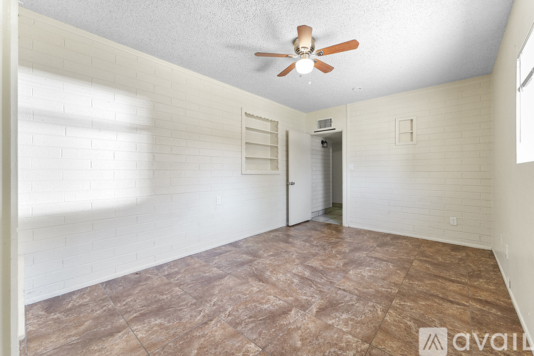 A room with a ceiling fan and a door leading to another room.