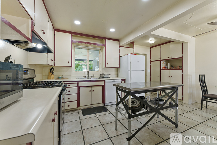 A kitchen with white cabinets and a black stove top oven.