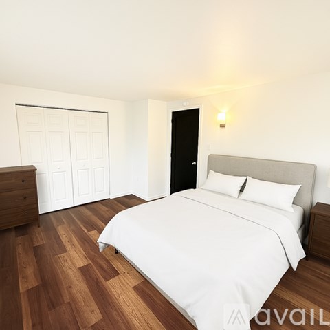 A bedroom with a large bed and wooden floors.