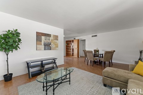 A living room with a glass table and a couch.