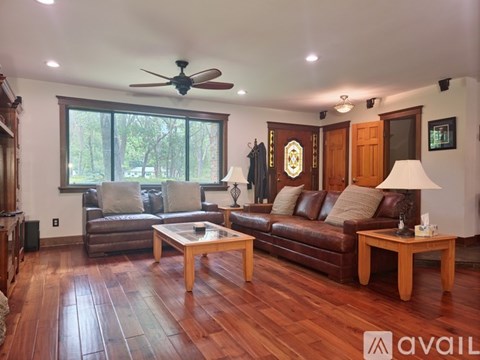 A living room with a brown leather couch and wooden coffee table.