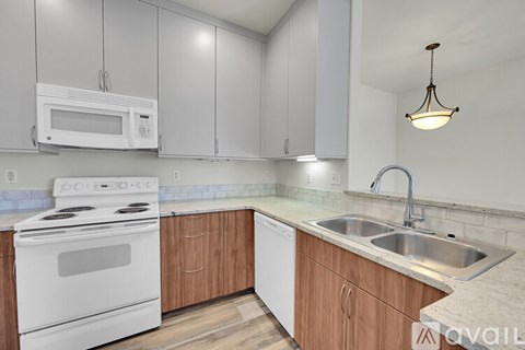 A kitchen with white appliances and wooden cabinets.