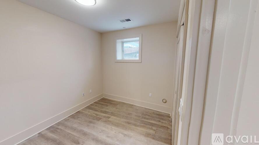 A room with a window and wooden flooring is available for rent.