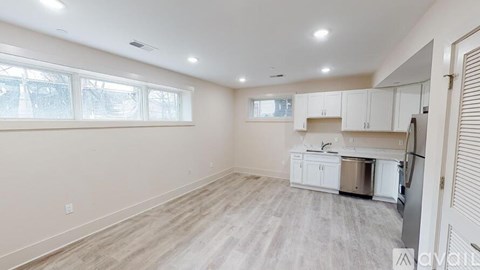 A kitchen with white cabinets and a refrigerator is shown.