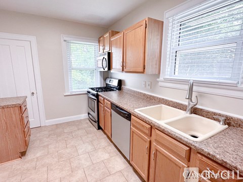 A kitchen with wooden cabinets and a white sink.