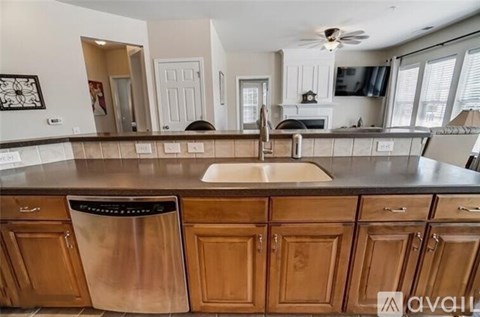 A kitchen with wooden cabinets and a stainless steel dishwasher.