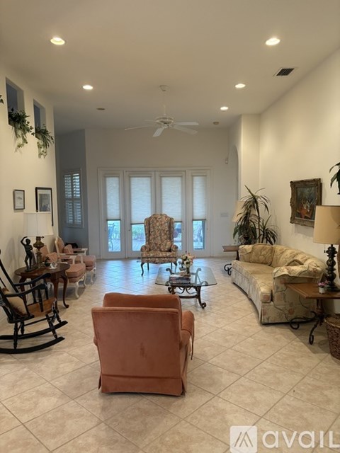 A living room with a rocking chair, a couch, and a coffee table.