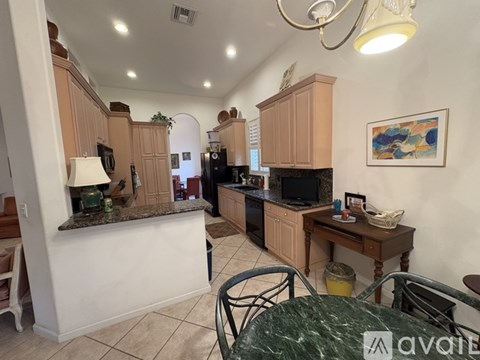A kitchen with wooden cabinets and a green marble table.