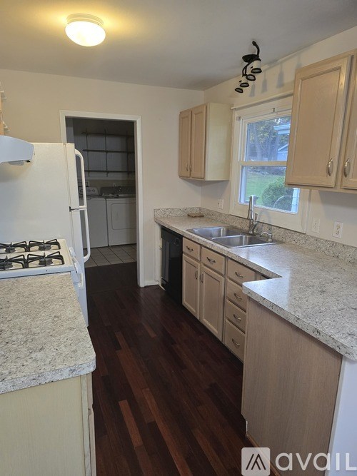 A kitchen with wooden floors and white appliances.