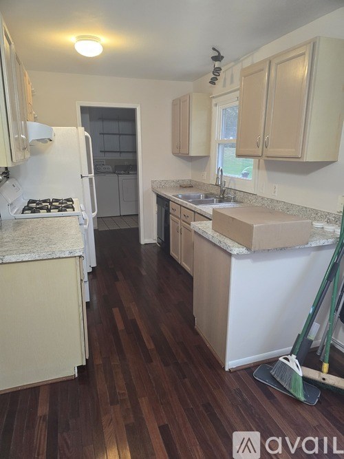 A kitchen with wooden floors and white appliances.