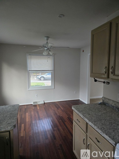 A room with wooden floors and a ceiling fan.