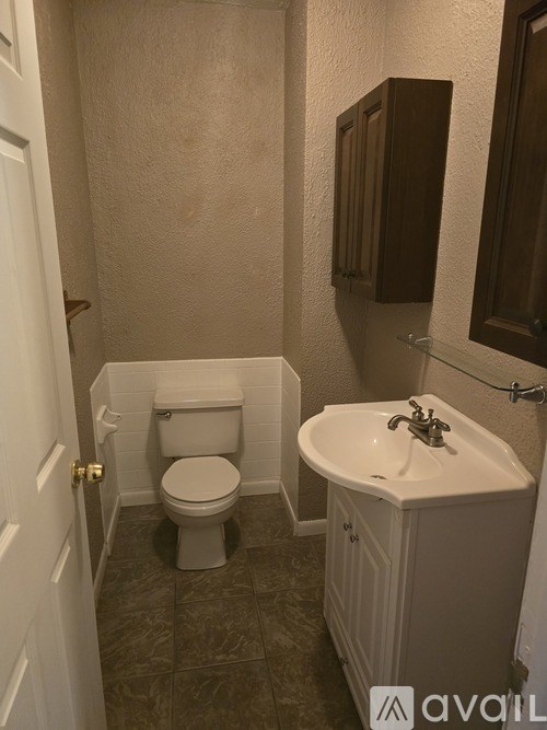 A white toilet and sink in a small bathroom.