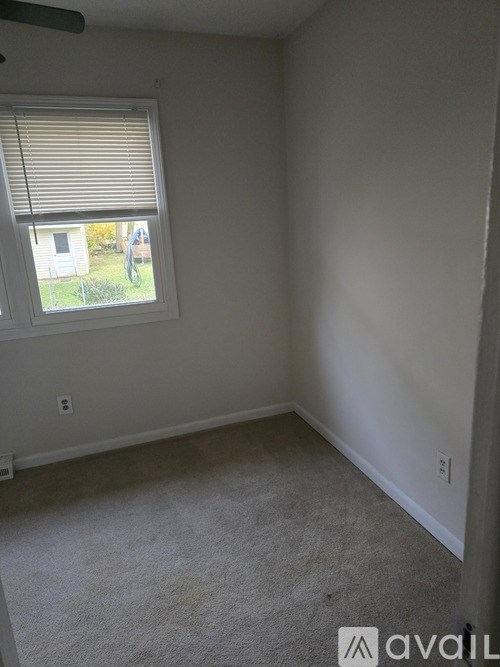 A room with a window and a car parked outside.