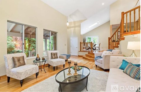 A living room with a glass coffee table and a white sofa.