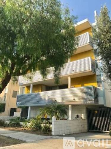 A modern two-story building with a balcony and a gate.