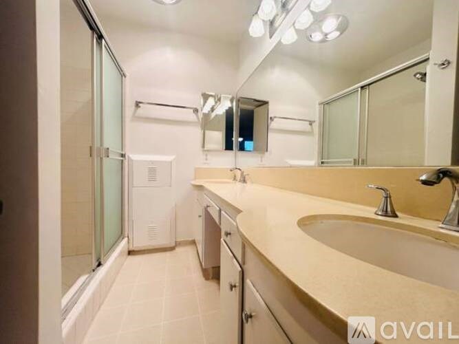 A bathroom with a sink, mirror, and shower.