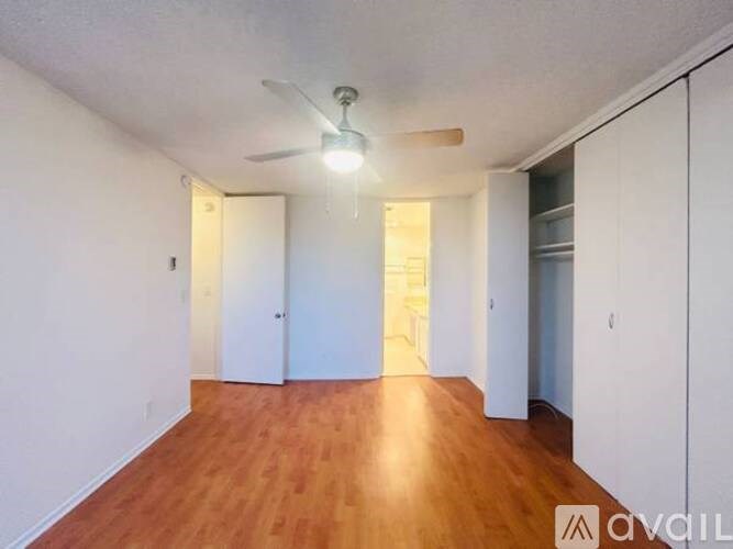 A room with wooden floors and a ceiling fan.
