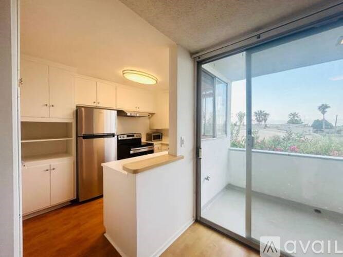 A kitchen with white cabinets and a stainless steel refrigerator.