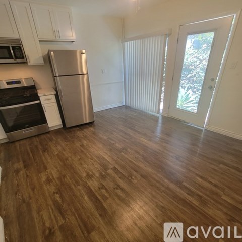 A kitchen with a stove top oven and a refrigerator.