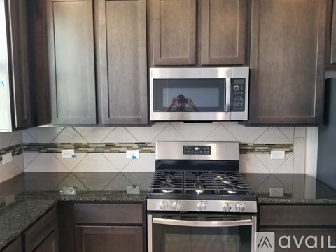 A modern kitchen with a stainless steel microwave and oven.