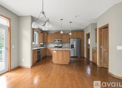 A spacious kitchen with wooden floors and a central island.