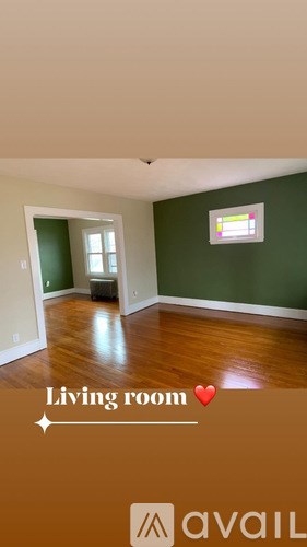 A living room with a green wall and a window.