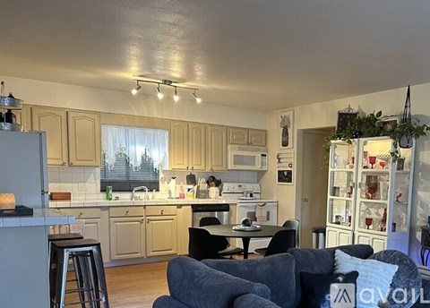 A kitchen with a table and chairs in the foreground.