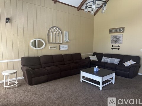 A living room with a black sofa and a white coffee table.