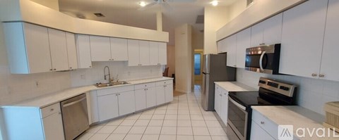 A kitchen with white cabinets and appliances.