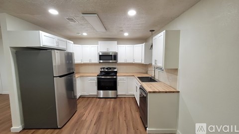 A kitchen with a refrigerator, oven, and stove top.
