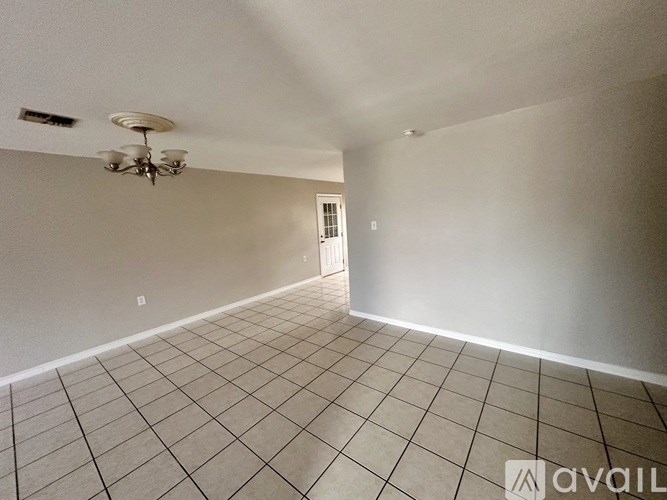 A room with a chandelier and a door.