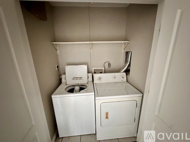 A small laundry room with a washer and dryer.